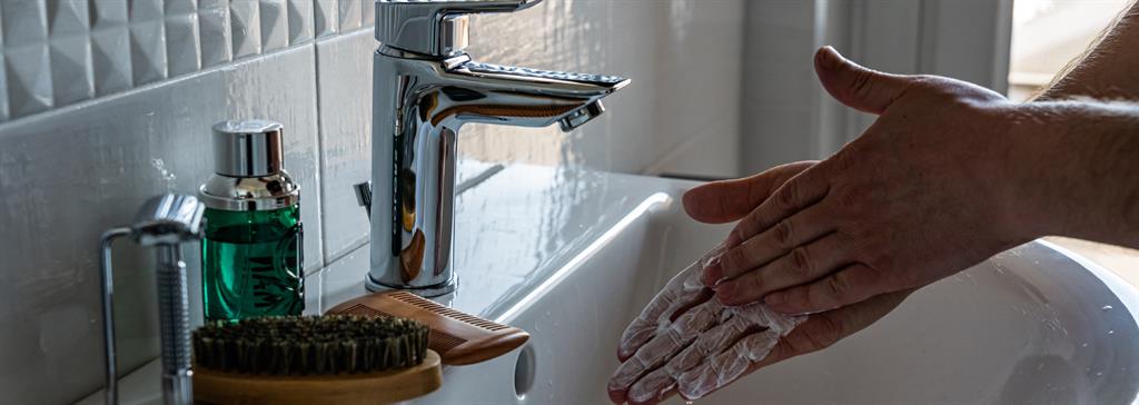 Close up of hands being washed at a sink